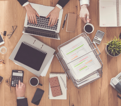 Topdown view of a table with papers and computers on it
