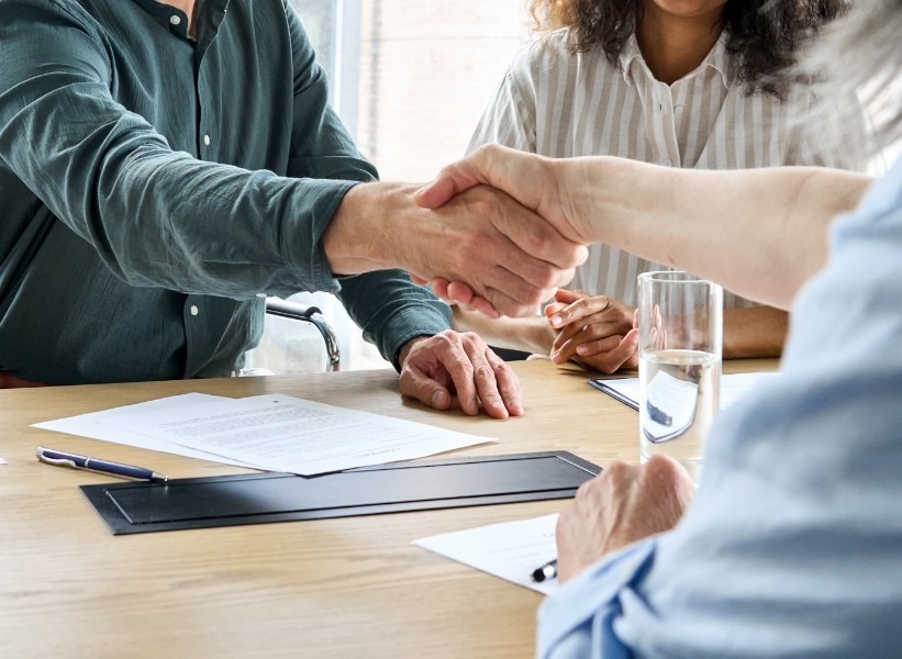 People at a table shaking hands